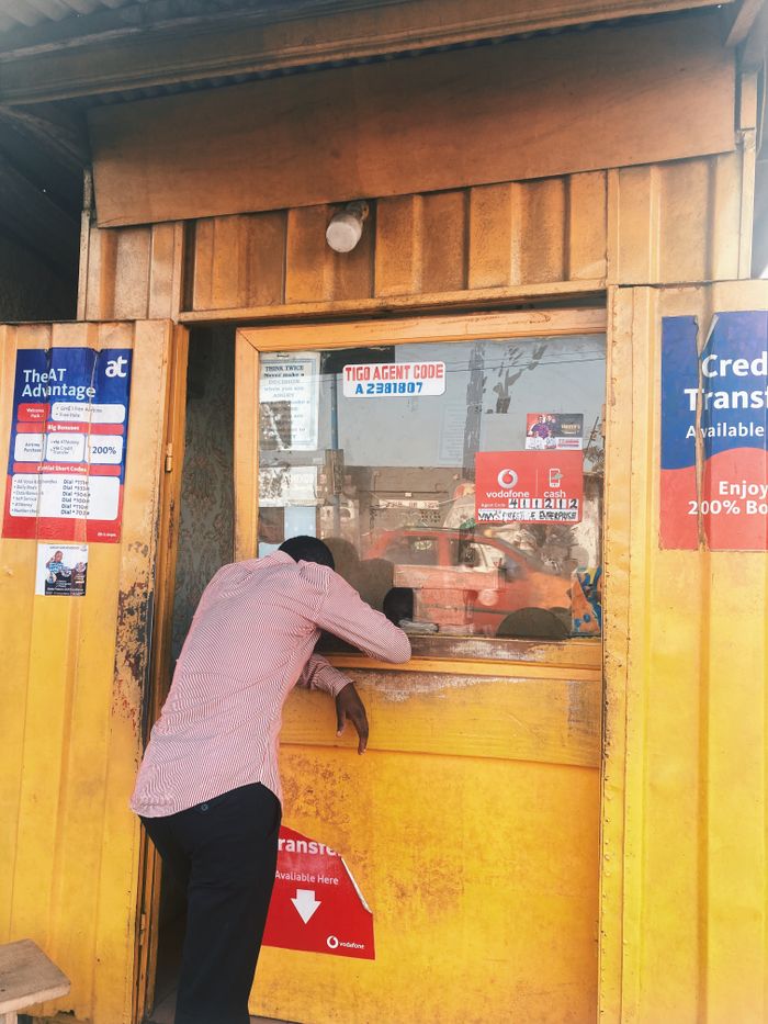 Man engaging with a street vendor in Accra, showcasing local commerce.